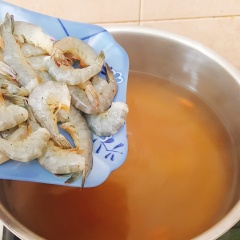 Đun sôi 2,5 lít nước. Cho me vào chén, múc nước sôi vào chén rồi dầm me cho me ra nước cốt. Cho nước me vào nồi, sau đó tiếp tục cho nước vào dầm tiếp. Sauk hi cho hết nước cốt me vào nồi, nêm vào 1/2 muỗng canh muối, 1 muỗng cà phê hạt nêm, 1 muỗng cà phê bột ngọt, 3 muỗng canh đường. Nấu cho nước canh sôi lại thì cho tôm vào nấu chín.