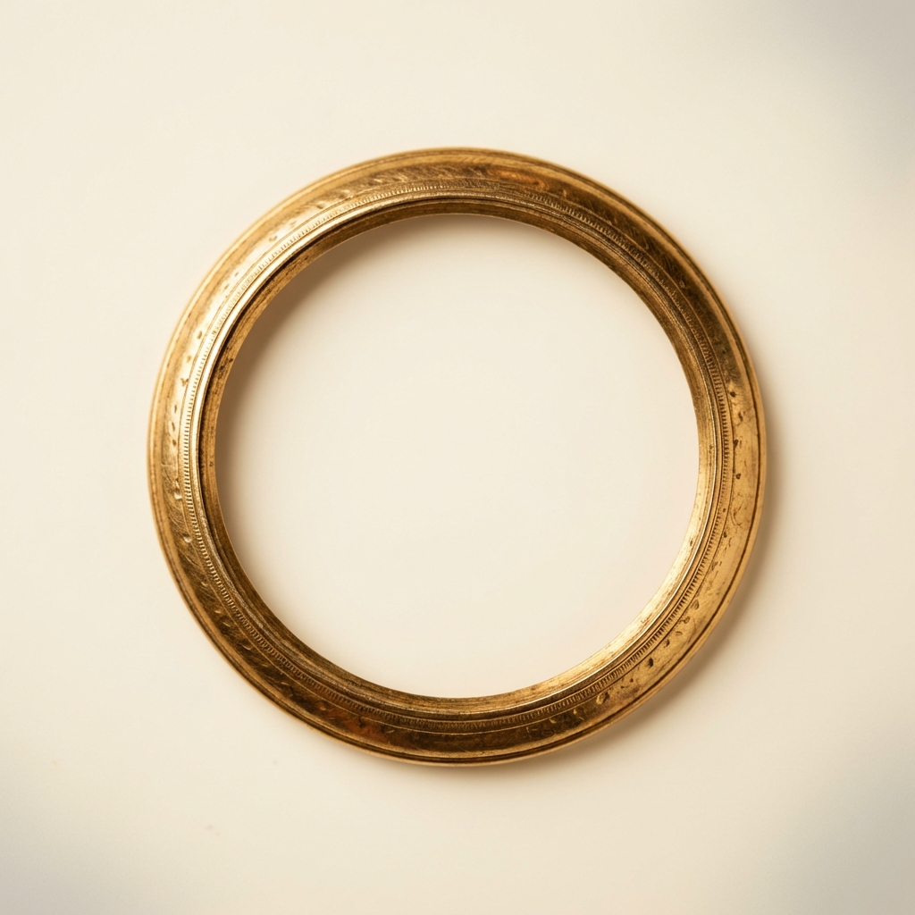 Macro full frame shot of a gilded gold ouroboros bezel under low magnification showing tooling marks and textured surface on warm ivory background ede7da