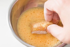 Lấy một cái chén, đập trứng vào đánh tan, sau đó cho thịt gà đã lăn qua bột nhúng vào chén trứng.