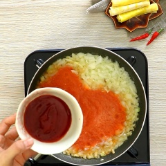 Bắc chảo, phi thơm 1 muỗng canh tỏi băm, cho tiếp 50gr hành tây xắt hạt lựu vào xào thơm, đổ hỗn hợp cà chua vào, cho 2 muỗng canh tương cà vào và khuấy đều hỗn hợp cho sôi. Sau đó, 300gr thịt bò xay vào tiếp tục đảo đều.