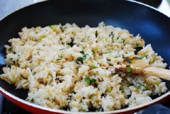 Vặn lửa lớn, thêm 2 muỗng canh dầu và cho nốt chỗ hành lá còn lại vào, đảo đều cho hành thơm rồi cho nước tương vào. Cho cơm vào chiên cho cơm săn lại. Sau đó cho trứng trở lại chảo, đảo đều cho trứng bám vào cơm. Thêm muối, tiêu, dầu mè, mè rang vào đảo thật đều là xong.