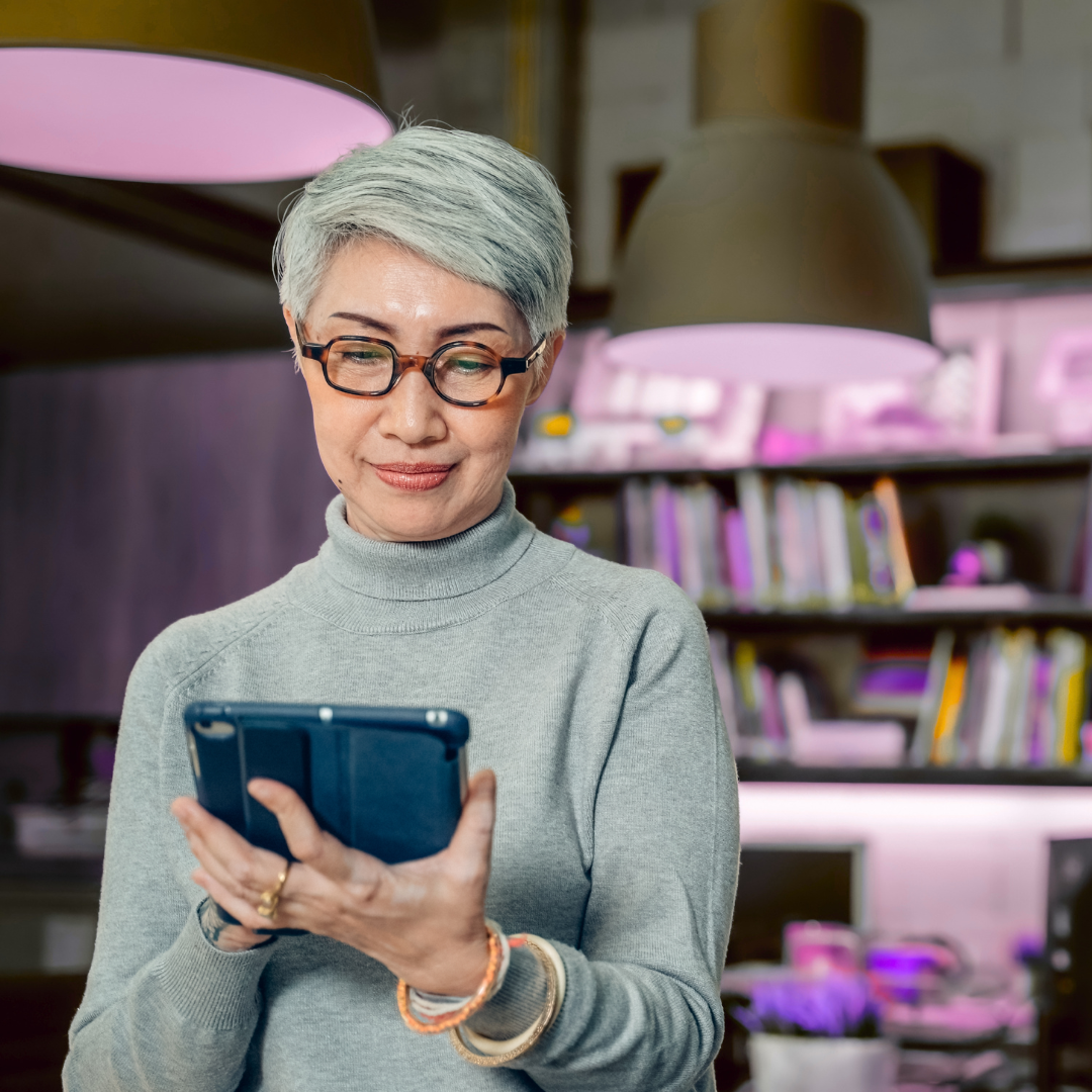 A woman reading on a tablet at home