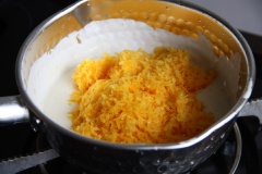 Đun đến khi hỗn hợp bám 1 lớp mỏng ở muôi thì cho thêm 100gr phô mai Cheddar bào sợi vào khuấy cho tan. Nêm nếm lại với chút muối tiêu cho vừa miệng.