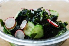 Pha nước trộn salad, cho giấm, đường, nước tương, muối, tỏi băm vào 1 cái tô trộn, khuấy cho tan đường và muối. Khi dùng, bạn rưới nước trộn salad vào tô rong biển, dưa leo, củ cải đỏ rồi trộn đều, rắc mè trắng rang lên là xong.
