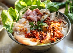 Cho rau xanh và bún tươi vào tô. Xếp thịt luộc, mít non, nem chả & thịt heo quay lên trên. Rồi thêm 1 ít dầu màu điều, đậu phộng rang và hành phi. Dọn kèm với mắm nêm là có thể thưởng thức rồi nhé.