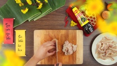 Chuẩn bị sẵn 400gr tai heo đã làm sạch và 500gr thịt chân giò rút xương. Bắc lên bếp 1 nồi nước, thêm vào 1/2 muỗng canh muối, 5gr gừng thái lát và 5gr sả cắt khúc, sau đó gắp tai heo và thịt chân giò vào luộc 15 phút. Vớt tai heo ra cho vào tô nước đá lạnh, thêm vào 2 lát chanh để giúp tai và thịt trắng giòn hơn. Sau khi ngâm nguội hẳn, vớt tai heo và thịt chân giò ra để ráo nước rồi cắt thành những lát mỏng.