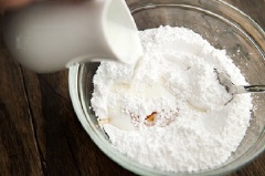 Để bánh trên giá hay rổ nhôm cho nguội và ráo dầu. Làm đường phủ: trộn đều sữa, mật ong và đường bột đến khi bạn có được một hỗn hợp sánh mịn.