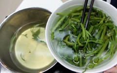 Cho rau muống vào luộc chín, bật lửa lớn để rau luộc không bị ê. Sau khi rau chín vớt rau ra tô nước lạnh để rau không bị sậm màu và giòn hơn. Sau đó vớt ra rá để thật rao nước.