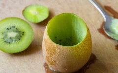 Kiwi cắt miếng nhỏ trên đầu trái kiwi, dùng muỗng múc lấy phần thịt kiwi, giữ lại phần vỏ.