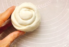 Rắc ít bột chống dính ra mặt phẳng, cho khối bột ra, cán mỏng dẹp rồi rắc vào hành lá đã thái, tiêu Mexico rồi cuộn lại thành trụ dài. Tiếp tục cuộn lại thành bánh xe rồi cán mỏng dẹp ra.