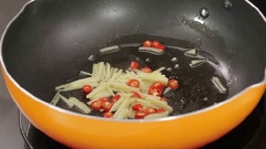 Đun nóng 2 muỗng canh dầu ăn, gừng và ớt vào xào thơm rồi cho thịt bò đã ướp vào, mở lửa lớn, đảo nhanh tay.