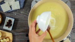 Lọc hỗn hợp hạt sen đã xay mịn qua rây vào một chiếc chảo chống dính, cho thêm 60gr đường và 30ml dầu dừa vào khuấy đều. Sên khoảng 5 phút sau khi tất cả hoà quyện thì cho hết 30ml dầu dừa còn lại vào, tiếp tục sên lửa vừa cho đến khi thấy nhân hơi sệt. Pha loãng 10gr bột mì với 30ml nước lọc, chế hỗn hợp vào chảo rồi khuấy đều, lúc này bạn sẽ thấy nhân đặc hơn rất nhiều.