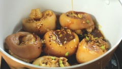 Bắc nồi kho lên bếp, cho chút dầu ăn và hành tím vào phi thơm, sau đó cho chân giò đã ướp vào đảo đều cho săn. Thêm vào 250ml nước dừa tươi, để lửa nhỏ và kho liu riu đến khi nước gần sệt lại thì cho dứa và nấm rơm đã xào vào. Nấu thêm khoảng 5 phút nữa thì cho hành lá và ớt và đảo đều để tạo màu đẹp mắt rồi tắt bếp.