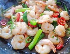 Lúc này cho ớt sừng, lá chanh và hành lá vào đảo đều, nêm nếm lại cho vừa ăn. Cuối cùng cho tôm vào. Trộn đều cho tôm sốt me ngấm gia vị thì tắt bếp.