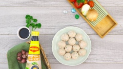 Ướp 300gr chả cá ba sa với 10gr hành tím băm, 10gr thì là, 10gr đường và 1 muỗng canh nước tương Maggi. Quết nhuyễn để chả cá được dai. Rửa sạch trứng cút, luộc chín rồi bóc vỏ. Thoa một ít dầu ăn lên bao tay cho khỏi dính, ấn dẹt miếng chả cá, đặt quả trứng cút vào giữa rồi vo tròn lại.