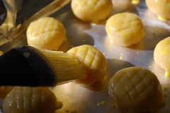 Làm dẹp phần vỏ bánh rồi cho nhân vào giữa, bao đều vỏ ra ngoài giống như làm bánh sủi cảo, dùng dao khía những đường chéo nhau trên mặt bánh. Tiếp đến, dùng cọ quét một lớp lòng đỏ trứng lên bánh.