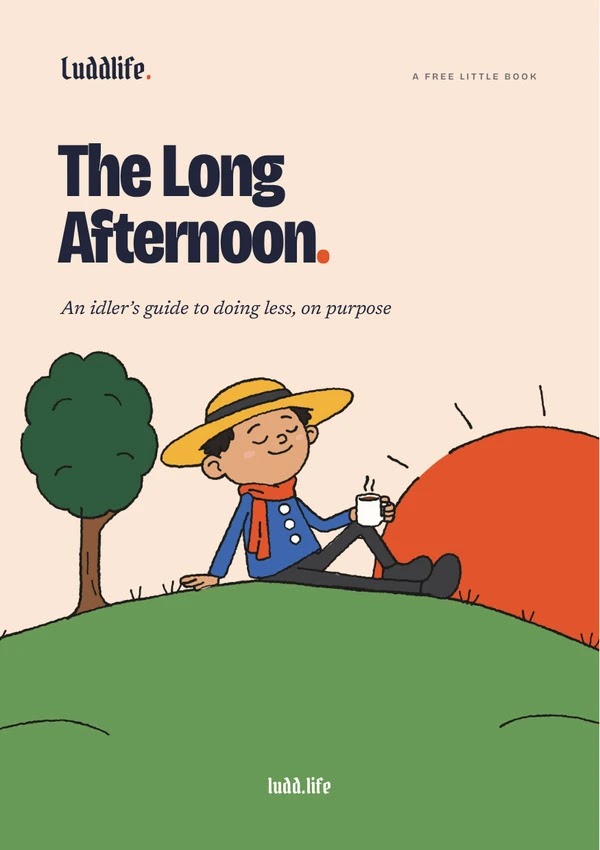 The cover of The Long Afternoon, an idler&rsquo;s guide to doing less, on purpose. A man in a straw hat sits in the grass on a hill at dawn with his mug, eyes closed. A big sun is coming up behind the hill, and a round tree keeps him company.