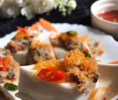 Cho bánh ra đĩa, thêm phần nhân, tôm khô lên. Bánh mềm, mịn ăn rất mềm. Chan kèm nước mắm lên thì ngon không tả.
