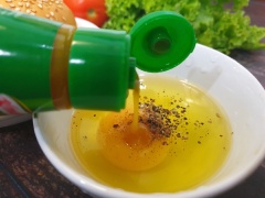 Đập trứng gà vào chén rồi thêm gia vị: xốt nêm, tiêu xay đánh đều. Chuẩn bị một chảo với ít dầu rồi cho trứng vào trong khuôn tròn chiên vàng 2 mặt với lửa nhỏ.