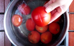 Cà chua khía nhẹ vài đường trên trái cà, cho vào nồi luộc sơ để dễ lột vỏ. Cắt đôi, bỏ hạt. Tỏi rửa sạch bóc vỏ .