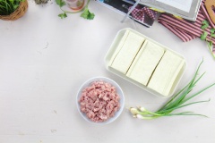 Đậu hũ trắng cắt làm 3, dùng muỗng nhỏ múc một miếng ruột bên trên miếng đậu hũ, cho ruột vào 1 tô để riêng. Làm lần lượt đến hết.