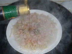 Cho 2 muỗng canh nước tương, ớt, hành lá vào. Lấy món hấp ra.