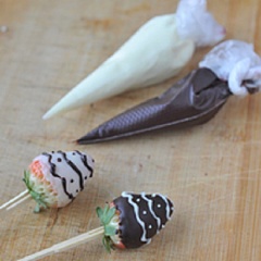 Cho riêng 2 chocolate lỏng còn lại vào 2 túi bóp kem. Khi các que dâu khô lại thì trang trí tùy thích.