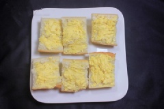 Dùng muỗng phết hỗn hợp bơ tỏi vào miếng bánh mì. Xếp bánh mì vào khay rồi cho vào lò nướng nướng ở 180 độ C trong khoảng 5 phút hoặc cho đến khi bơ tan chảy và bánh đã giòn là được. Lấy bánh ra rắc ngò rí lên trên và thưởng thức.