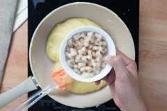 Kế đến là cho mỡ đường đã trong, sầu riêng xay nhuyễn vào cùng chảo đậu xanh. Dùng phới trộn đều để các nguyên liệu hòa trộn vào nhau. Khi thấy nhân bánh pía Sóc Trăng khô lại, có thể dùng tay vo được thì tắt bếp. Chia ra thành 10 phần bằng nhau rồi vo tròn lại.
