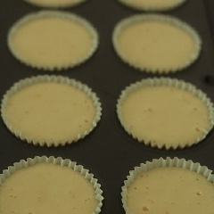 Lót cốc giấy vào khuôn cupcake, múc hỗn hợp bánh vào, dàn đều.