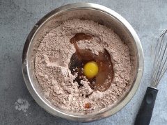 Mở lò nướng sẵn ở 177 độ C. Trong âu lớn, cho 600g đường bột, 75g bột cacao không đường, 1 muỗng bột bắp, 1/4 muỗng muối, 1/2 muỗng muối và trộn thật đều. Sau đó cho lòng trắng trứng, trứng gà và tinh chất vào hỗn hợp bột rồi trộn cho tất cả hào quyện đều thành hỗn hợp bột mịn là được. Cuối cùng thêm chocolate chip vào đảo đều lên.