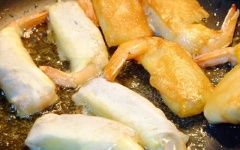 Đun sôi dầu ăn trong chảo, cho chả giò cuộn vải tôm vào, chiên vàng giòn. Thỉnh thoảng lật đều để chả giò không bị cháy.