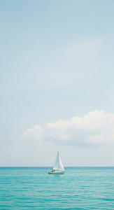 Minimalist Photograph of a White Sailboat on a Calm Turquoise Ocean Under a Soft Sky