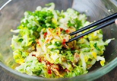 Dùng tay vắt kiệt nước cải thảo. Cho cải thảo, tỏi, gừng, tương ớt, đường trắng, giấm, hành lá vào tô, trộn đều.
