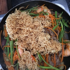Cho tiếp cà rốt và rau muống vào xào đều. Cho tiếp phần mì gói đã làm chín vào, đảo đều tay để mì thấm gia vị.