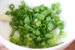 Chả cá thác lác cho vào tô cùng 1 muỗng canh nước mắm, 1/2 muỗng cà phê tiêu, trộn đều, vo thành từng viên tròn, nhỏ. Hành lá rửa sạch, cắt nhỏ.