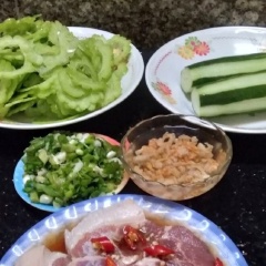 Khổ qua rửa sạch, cắt khía một bên rồi dùng muỗng nạo sạch. Cắt bỏ cuống rồi xắt thành miếng mỏng. Tôm khô ngâm nước nóng 5 phút rồi đổ nước đi, để ráo một chút rồi băm nhỏ. Hành lá băm nhỏ rồi để riêng dùng khi nấu canh xong để trang trí.