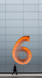 Minimalist Street Portrait of a Man Walking Past a Giant Curved Steel Wall with Orange Light Accent