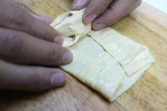 Trải 1 miếng tàu hũ ky ra thớt hoặc mặt phẳng. Múc 1 muỗng nhân đặt vào một góc mép mặt trong tàu hũ ky. Cuộn 1 vòng, đừng cuộn chặt tay, lần lượt gấp 2 bên vào, tiếp tục cuốn tròn lại như cuốn chả giò bình thường. Làm lần lượt hết số nhân vào tàu hũ ky.