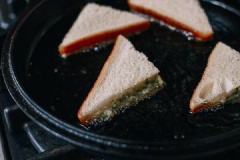 Trong một cái chảo chống dính, đun nóng dầu ăn. Cho từng lát mì sandwich vào chiên đến khi vàng đều hai mặt thì vớt ra, lót giấy thấm dầu để dầu ăn rút bớt.