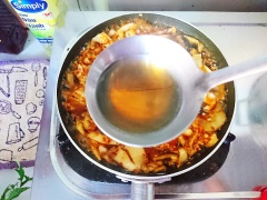 Tiếp tục thêm nước kim chi, đường, ớt bột và nước mắm vào chảo cá. Đun với lửa nhỏ chú ý khi đun lật mặt cá, giúp cá thấm vị từ kim chi và cải chua ngon hơn.