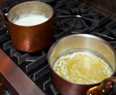 Dùng lại nồi luộc nui, cho 30g bơ vào nồi và đun chảy. Cho tiếp kem whipping và phô mai Parmesan vào nồi, khuấy đều nhé.