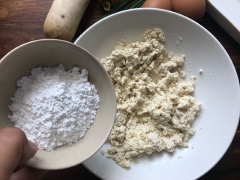 Khi đã nghiền mịn đậu hũ trắng thì cho 6 muỗng canh bột năng và 3 muỗng canh bột gạo vào, dùng muỗng xới đều lên. Sau đó dùng tay nhồi quyện đều thành khối đồng nhất.