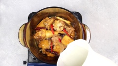 Cho 2 muỗng canh dầu ăn vào nồi, cho 3gr xuyên tiêu, 5gr ớt khô nguyên trái, 5gr ớt tươi vào đảo đều. Cho gà đã ướp vào xào săn khoảng 3 phút. Kế đến cho vào nồi 1,5 lít nước lọc, nấu chín gà 10 phút, hớt bọt cho nước lẩu được trong.