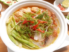 Chần bún bằng nước nóng rồi cho vào bát tô, xếp chả cá, cá chiên giòn cùng dọc mùng và hành lá, rau răm, thì là. Từ từ chan phần nước dùng vào thưởng thức khi bún cá còn nóng hổi.