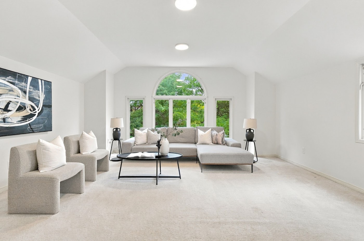 Upper level room with an arched window and brick fireplace