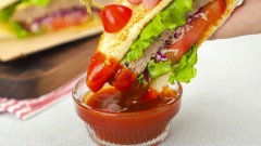 Khi dùng cắt đôi bánh sandwich khi còn nóng, ăn cùng tương ớt Maggi. Bánh sandwich có lớp vỏ giòn giòn, thơm mùi bơ, kẹp ở giữa là các loại rau cải tươi mát, phần thịt mềm mọng, chấm kèm với tương ớt Maggi càng làm tăng thêm hương vị sẽ khiến cho bạn càng ăn càng mê.
