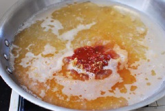 Đầu tiên chuẩn bị nguyên liệu: bánh gạo để rã đông, chả cá cắt 4cm, hành lá cắt khúc dài 2cm, bắp cải cắt miếng 4cm, rửa sạch. Chế 360ml nước dùng vào nồi và cho tất cả nguyên liệu gồm 3 muỗng tương ớt, 3 muỗng ớt bột, nước tương, đường, siro bắp và tỏi băm vào nấu sôi.