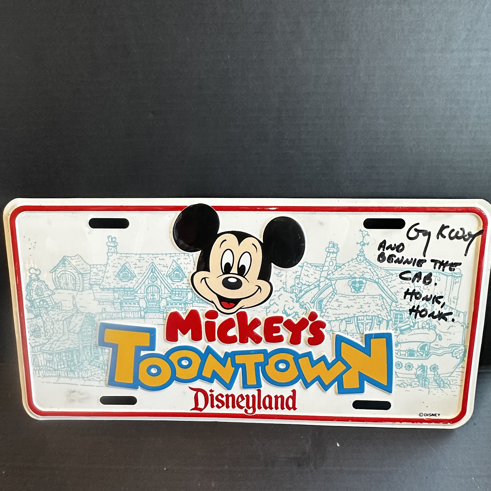 Metal Disneyland souvenir license plate from Mickey's Toontown, 6 by 12 inches, with a signed inscription referencing Benny the Cab and the text HONK HONK