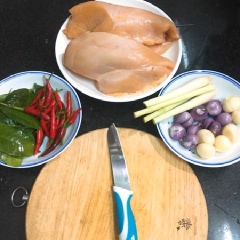 Thịt ức gà lọc bỏ da và mỡ thừa. Luộc thịt ức gà với 1 củ hành tím, gừng, phần ngọn sả. Nước sôi cho gà vào, cho thêm 1 muỗng canh muối, 3 muỗng cà phê hạt nêm, đun 7-10 phút gà chín vớt ra để nguội rồi xé sợi vừa ăn (xé to 1 chút cho nó đỡ nát nhé!). Tỏi, hành tím, ớt, sả cắt nhỏ, bỏ vào cối giã nhuyễn. Giã thì tinh dầu ra sẽ thơm hơn bằm. Xong cho vào bột ớt, bột ngũ vị hương, gia vị nấu bò kho, 1 muỗng cà phê hạt nêm, đường và nước mắm, đảo đều cho thấm.